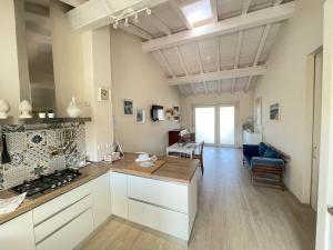 a kitchen with white cabinets and a table in a room at Camere LaVigna in Carrara