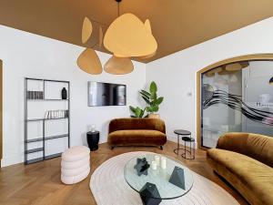 a living room with a couch and a glass table at Maison 65 in Pierrelatte