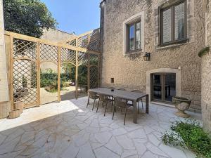 a patio with a table and chairs in front of a building at Maison 65 in Pierrelatte