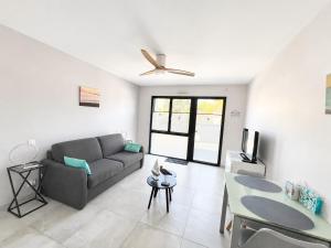 a living room with a couch and a ceiling fan at Studio rez-de-jardin la Baule proche centre Pornichet in La Baule