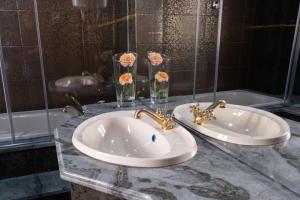 a bathroom with two sinks and two vases with flowers at Telesico Residencia in Pombal +19 photos