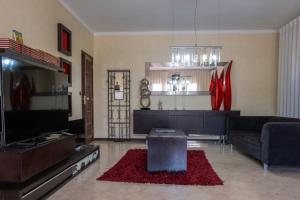 a living room with a couch and a flat screen tv at Telesico Residencia in Pombal