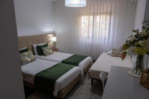 a hotel room with two beds and a table at Telesico Residencia in Pombal