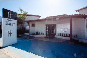 a house with a swimming pool in front of a building at Rede Andrade Galeão in Porto Seguro