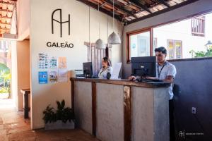 two people standing at a counter in a office at Rede Andrade Galeão in Porto Seguro