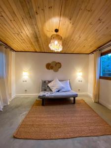 a bed in a room with a wooden ceiling at ANKAVIA Lodge in Toamasina