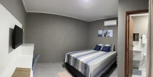 a bedroom with a bed with blue pillows at Pousada Recanto Sossego in Saquarema