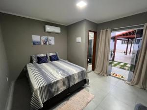 a bedroom with a bed and a sliding glass door at Pousada Recanto Sossego in Saquarema