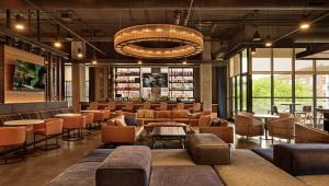 a lobby with a library with chairs and tables at Hyatt House Chicago West Loop-Fulton Market in Chicago