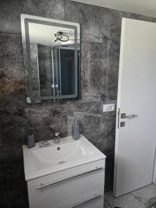 a bathroom with a white sink and a mirror at Casa Valor in Lacu Rosu