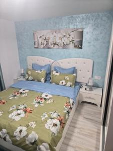 a bedroom with a bed with a floral bedspread at Casa Valor in Lacu Rosu
