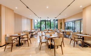 a restaurant with wooden tables and chairs and windows at Hồng Môn Resort Đà Lạt in Da Lat