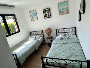 a bedroom with two beds and a window at Le Chalet de Kervignon in Plobannalec-Lesconil