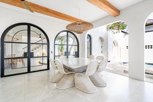 a dining room with a white table and chairs at Casa Contenta Canggu - Luxury 5BR Private Pool Villa in Canggu