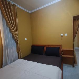 a small bedroom with a bed and a window at Tetebatu Clove Garden in Tetebatu