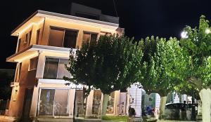 a building with trees in front of it at night at Evia Plaza Suites in Amarynthos