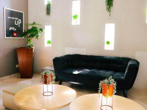 a living room with a black couch and two tables at ibis Antofagasta in Antofagasta