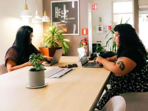 two women sitting at a table with their laptops at ibis Antofagasta in Antofagasta