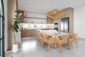 a kitchen and dining room with a table and chairs at Casa Contenta Canggu - Luxury 5BR Private Pool Villa in Canggu +21 photos