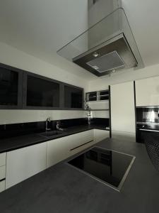 a kitchen with white cabinets and black counter tops at 2 Schlafzimmer Apartment Bergland 