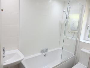 a white bathroom with a shower and a sink at Glasgow West End Accommodation in Glasgow