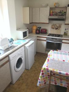 a kitchen with a washing machine and a microwave at Glasgow West End Accommodation in Glasgow