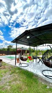 a pavilion with a picnic table and a swing at Rokiti Yard in Bagdatʼi