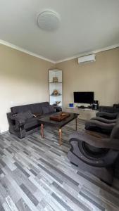 a living room with a couch and a table at Rokiti Yard in Bagdatʼi