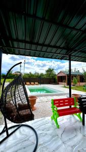 a patio umbrella with a bench and a swing at Rokiti Yard in Bagdatʼi