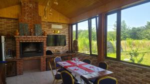 a dining room with a table and a fireplace at Rokiti Yard in Bagdatʼi