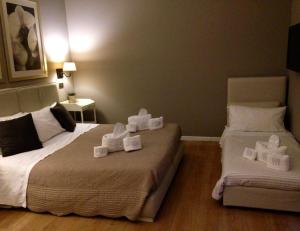 Dos camas en una habitación con toallas blancas. en Maxim en Palermo