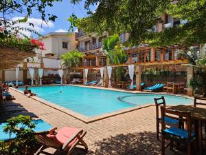 a large swimming pool with chairs and a hotel at Gassy Country House Ivato Airport in Ivato