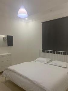 a bedroom with a white bed and a tv at شقة لك بالكامل in Taif