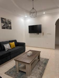 a living room with a couch and a coffee table at شقة لك بالكامل in Taif