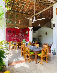 a dining room with wooden tables and chairs at Sunny's Garden Hotel in Ambalangoda