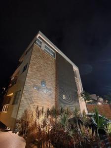 a brick building with a sign on the side of it at Refúgio dos Guaiás - Apart Hotel in Bombinhas