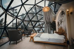 a bedroom with a large glass window and a bed at A'moss Farmstay in Cameron Highlands