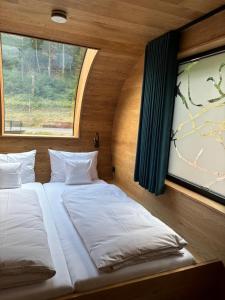 two beds in a room with a window at Wellness Chalet unterm Trifels in Annweiler am Trifels