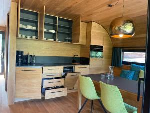 a kitchen with wooden cabinets and a table and chairs at Wellness Chalet unterm Trifels in Annweiler am Trifels +14 photos