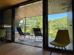 a room with chairs and a table on a balcony at Wellness Chalet unterm Trifels in Annweiler am Trifels