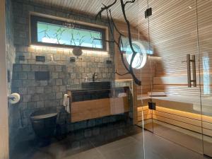 a bathroom with a sink and a toilet and a window at Wellness Chalet unterm Trifels in Annweiler am Trifels