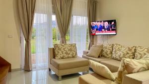 a living room with a couch and a flat screen tv at DreamStay Lezha - Villa in Shëngjin