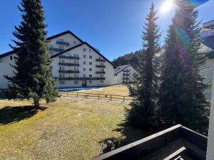 a view of a building with two trees in a yard at Slope-Side Mountain Apt Sleeps 4 in Laax