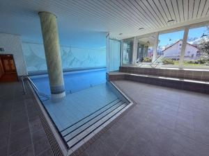 a swimming pool in a house with a glass door at Slope-Side Mountain Apt Sleeps 4 in Laax