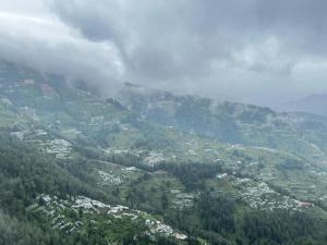 a view of a mountain with houses and trees at Treebo Fagu Peaks in Shimla