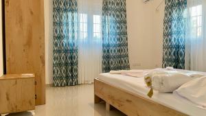 a bedroom with a bed with blue curtains at DreamStay Lezha - Villa in Shëngjin