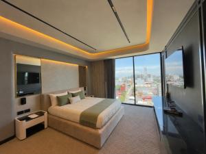 a bedroom with a large bed and a large window at PISO 13 SM Living Street Mall in Puebla