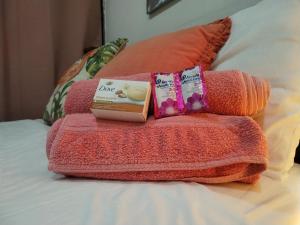 a pile of towels and a box on a bed at Carribean Boutique Hostel in San José
