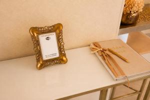 a gold frame sitting on a table next to a book at GOLDENSPACE by Evagelias Homes Volos in Volos