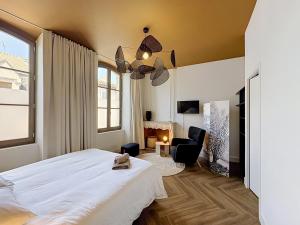 a bedroom with a white bed and a chair at Maison 65 in Pierrelatte